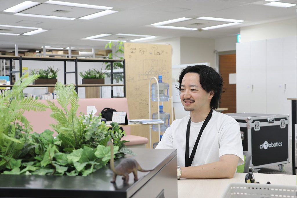座って話をするHさん。