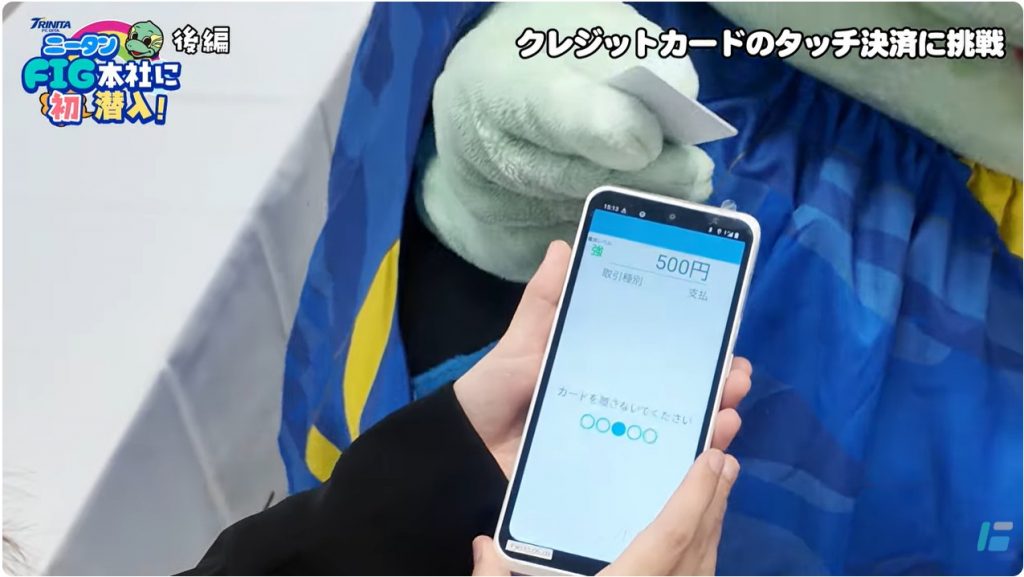 キャッシュレス決済端末PT-751でタッチ決済を体験するニータン。